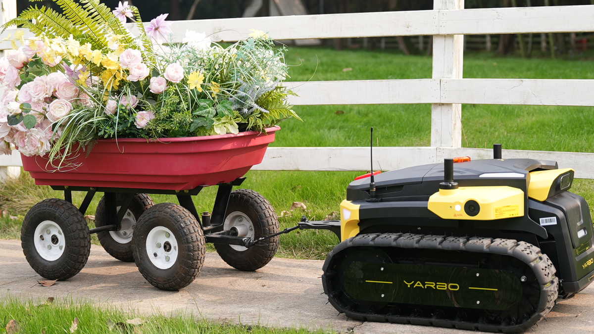 Yarbo Core towing a garden cart of flowers