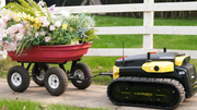 Yarbo Core towing a garden cart of flowers