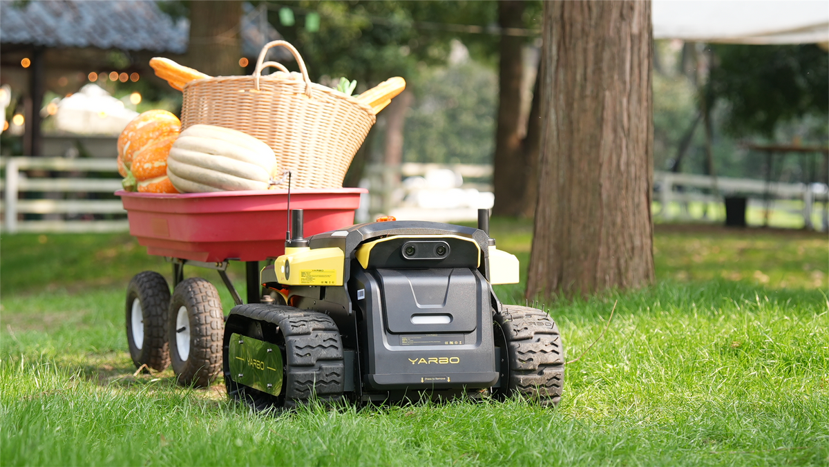 Yarbo Core pulling a cart of produce across grass