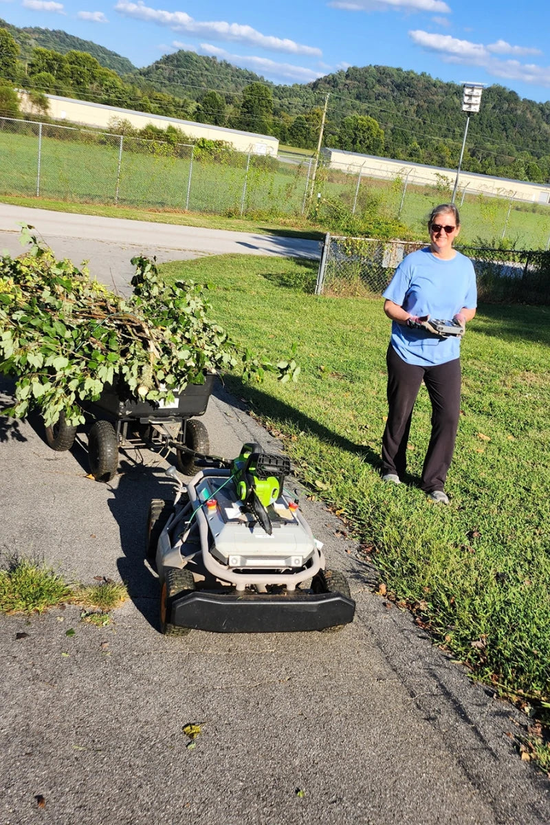 Woman mowing a hedge line with the Mowrator remote