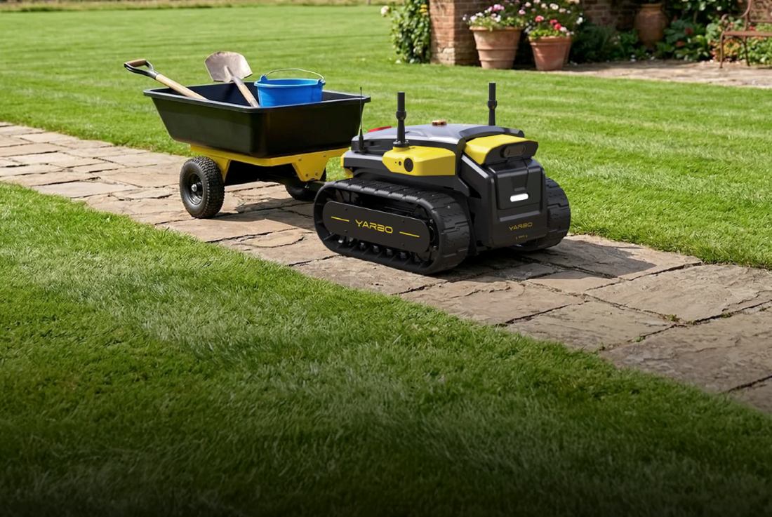 Yarbo Core towing a garden cart along a stone path