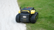 Yarbo Core robot on a lawn next to a gravel path