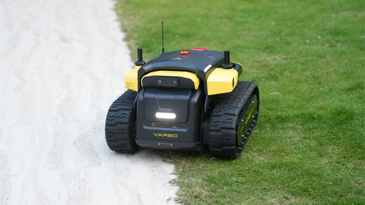 Yarbo Core robot on a lawn next to a gravel path